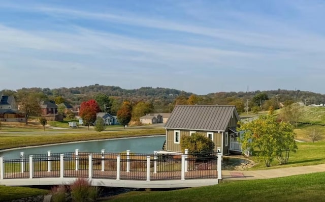 view of home's community with a water view and a lawn