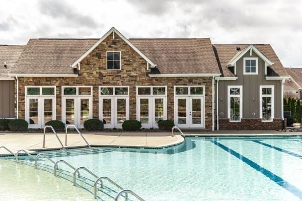 view of swimming pool featuring french doors