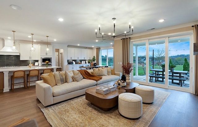 living room with an inviting chandelier and light hardwood / wood-style floors