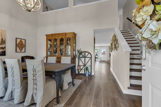 dining room with a high ceiling, dark hardwood / wood-style floors, and a notable chandelier