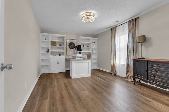 interior space featuring dark hardwood / wood-style flooring, white cabinets, and a textured ceiling