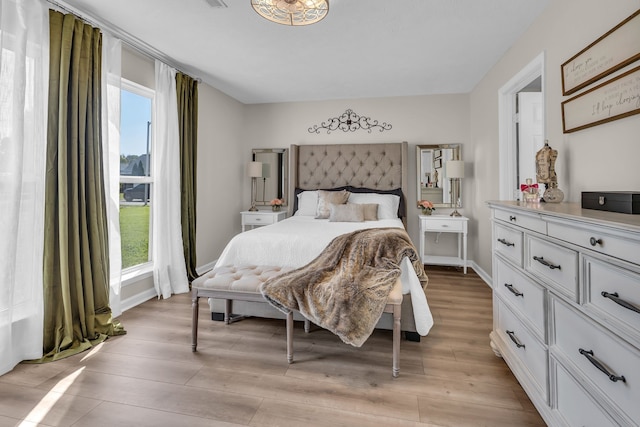 bedroom with light wood-type flooring and multiple windows