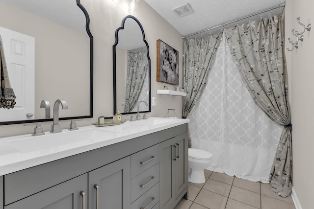 full bathroom featuring vanity, a textured ceiling, shower / bath combo with shower curtain, tile patterned flooring, and toilet