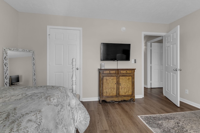 bedroom with wood-type flooring and a textured ceiling