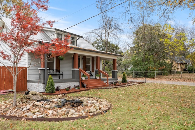 view of front of home with a porch and a front yard