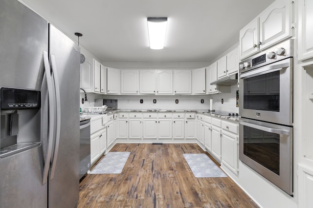 kitchen featuring tasteful backsplash, white cabinetry, dark hardwood / wood-style floors, and appliances with stainless steel finishes