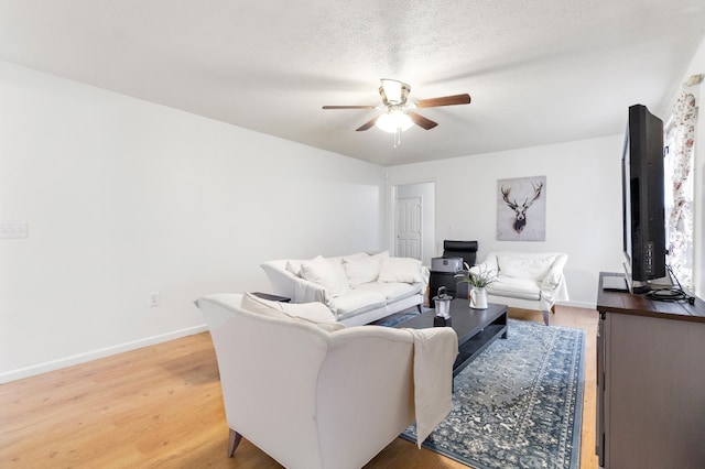 living room with hardwood / wood-style floors, a textured ceiling, and ceiling fan