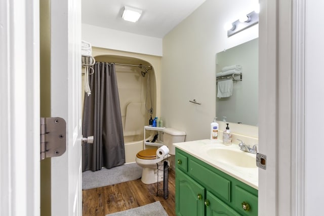 full bathroom with hardwood / wood-style floors, vanity, shower / tub combo, and toilet