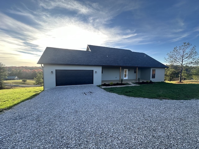 ranch-style house featuring a lawn and a garage