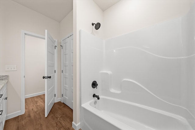 bathroom with hardwood / wood-style flooring, vanity, and  shower combination