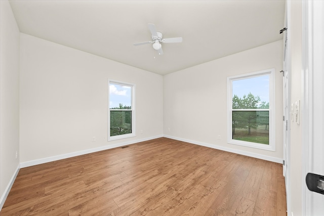 spare room featuring ceiling fan, a healthy amount of sunlight, and light wood-type flooring