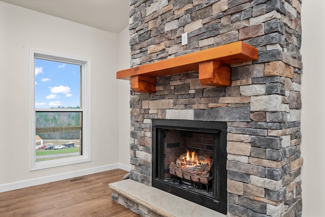 interior details with hardwood / wood-style floors and a stone fireplace