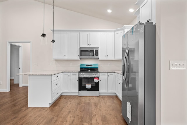 kitchen featuring lofted ceiling, white cabinets, decorative light fixtures, light stone counters, and stainless steel appliances