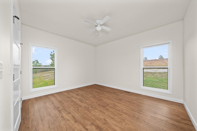 unfurnished room featuring light wood-type flooring, ceiling fan, and a healthy amount of sunlight