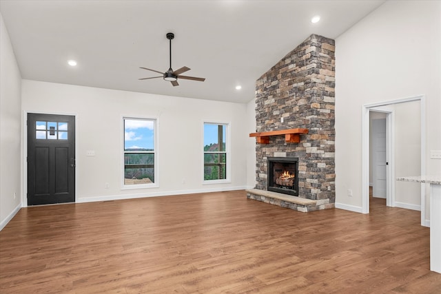 unfurnished living room featuring a fireplace, ceiling fan, hardwood / wood-style floors, and high vaulted ceiling