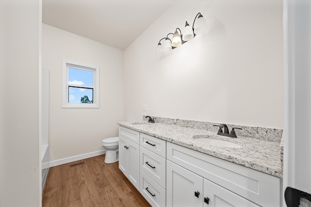 bathroom with hardwood / wood-style flooring, vanity, and toilet