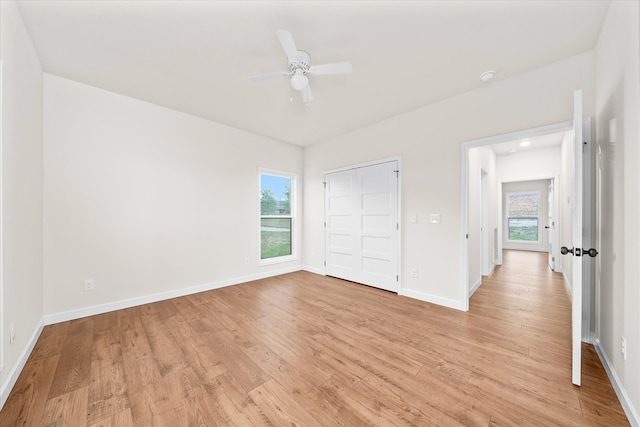 unfurnished bedroom with ceiling fan, a closet, and light hardwood / wood-style floors