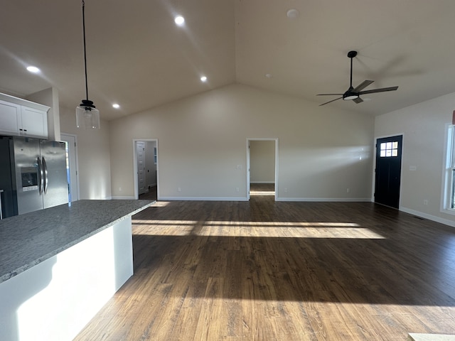 unfurnished living room featuring dark hardwood / wood-style floors, high vaulted ceiling, and ceiling fan