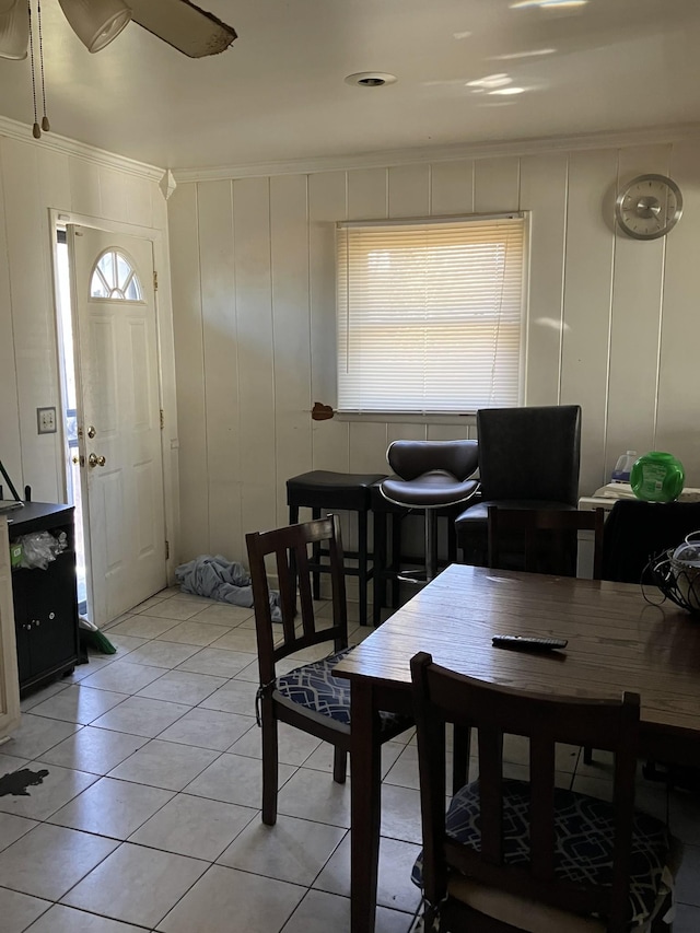 dining space with light tile patterned floors and ornamental molding