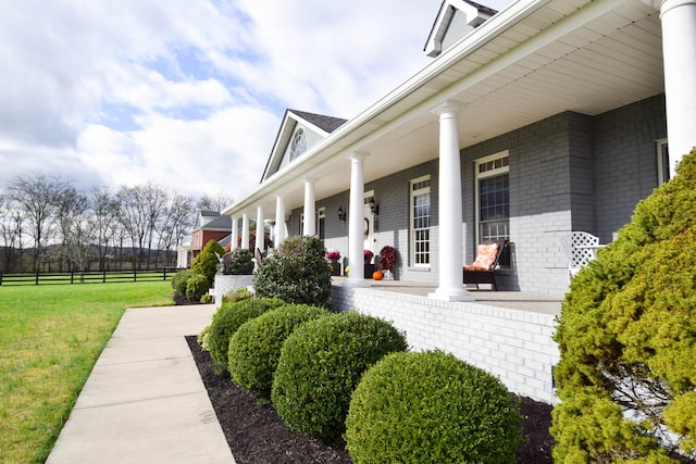 exterior space featuring covered porch and a lawn