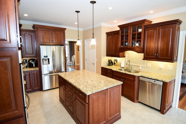 kitchen with pendant lighting, a kitchen island, crown molding, appliances with stainless steel finishes, and sink