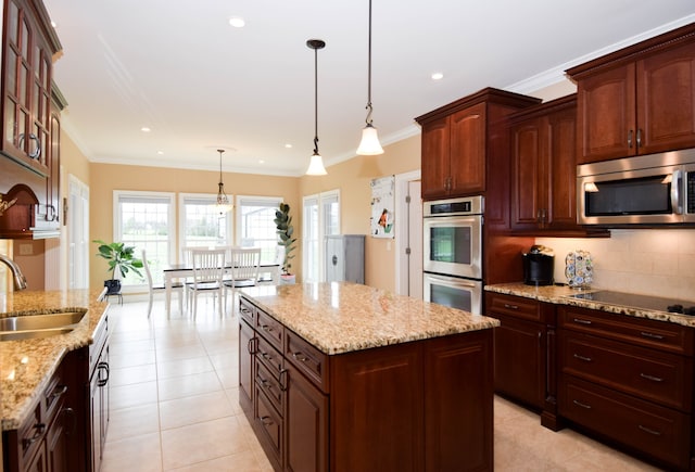 kitchen with stainless steel appliances, sink, light tile patterned floors, a kitchen island, and pendant lighting