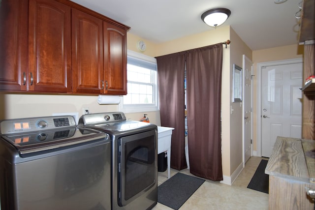 laundry room featuring washer and clothes dryer and cabinets