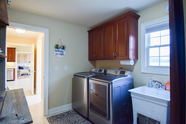 washroom featuring separate washer and dryer, cabinets, and sink