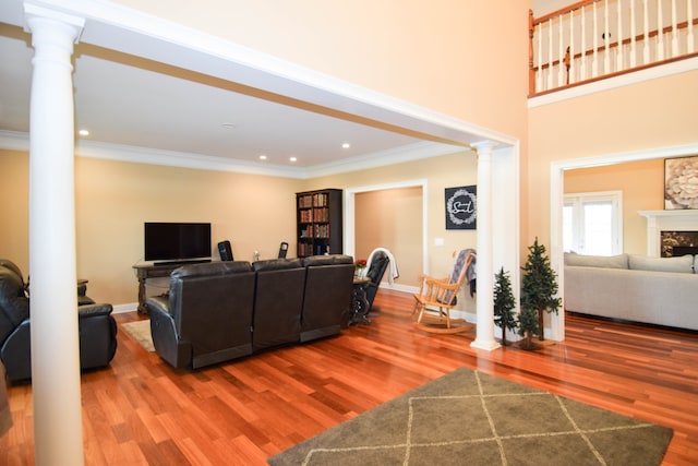 living room featuring a high end fireplace, wood-type flooring, and ornamental molding