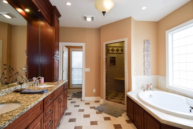 bathroom featuring vanity and independent shower and bath