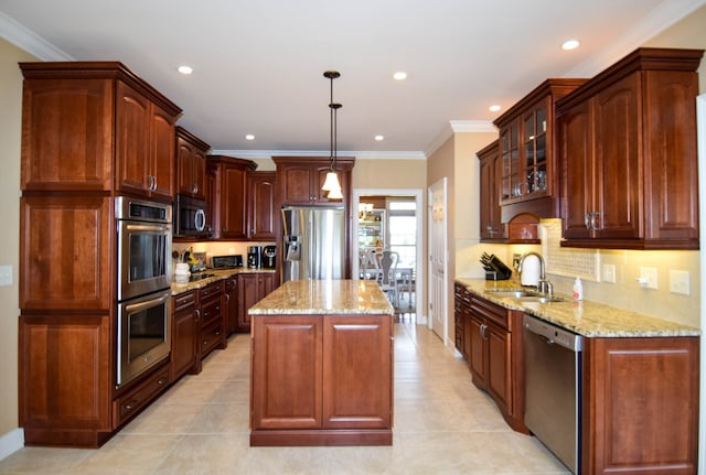 kitchen featuring light stone counters, a center island, decorative light fixtures, appliances with stainless steel finishes, and sink