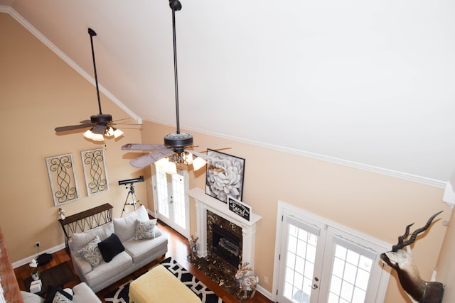 living room with ceiling fan, vaulted ceiling, a wealth of natural light, and a fireplace