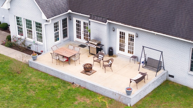 rear view of property featuring a fire pit, french doors, and a patio