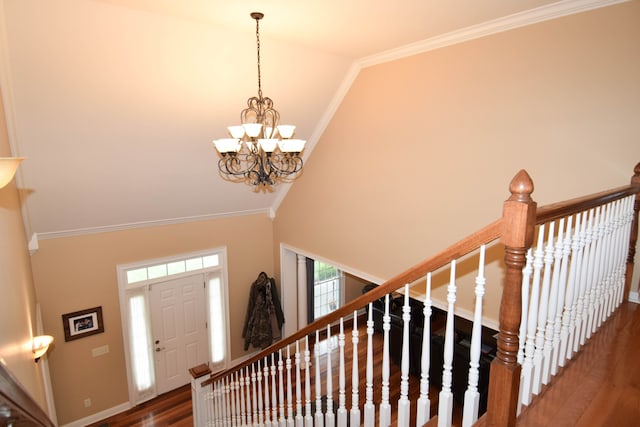 foyer featuring high vaulted ceiling, an inviting chandelier, crown molding, and dark wood-type flooring