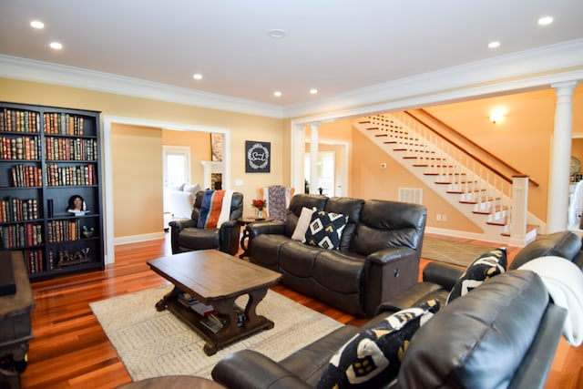 living room featuring ornamental molding, dark wood-type flooring, and ornate columns