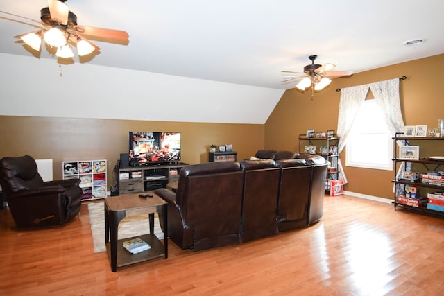 living room with ceiling fan, vaulted ceiling, and light hardwood / wood-style flooring