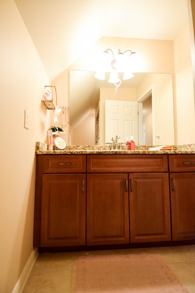 bathroom with tile patterned flooring, lofted ceiling, and vanity