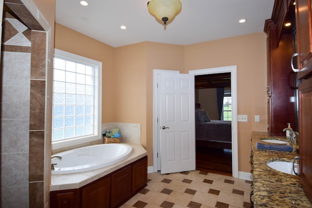 bathroom with a tub and vanity