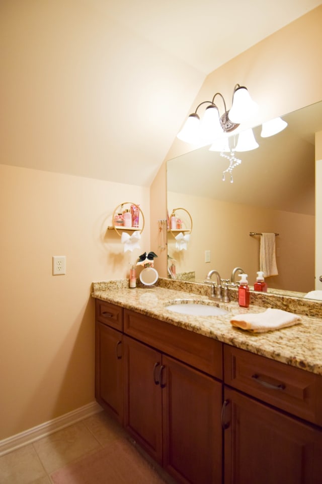 bathroom featuring tile patterned flooring, vaulted ceiling, and vanity