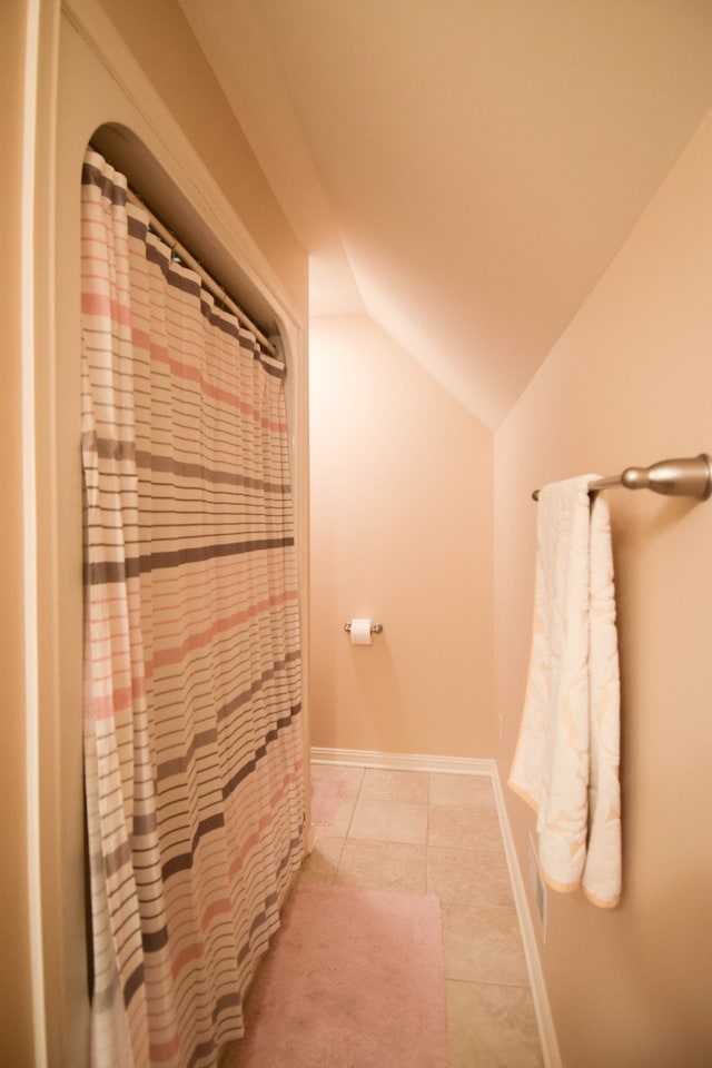 bathroom featuring tile patterned floors and vaulted ceiling