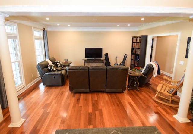 living room featuring crown molding, hardwood / wood-style floors, and decorative columns