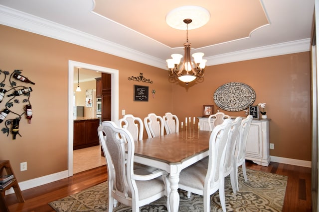 dining area featuring a notable chandelier, crown molding, and hardwood / wood-style floors