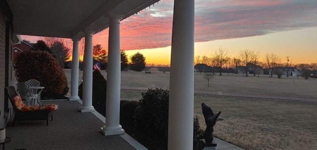 patio terrace at dusk featuring a yard