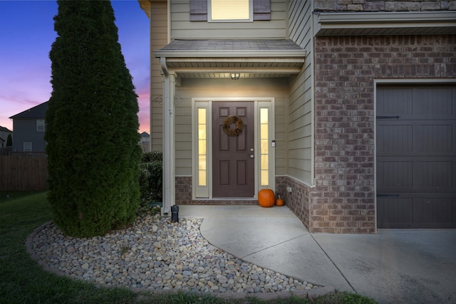 exterior entry at dusk featuring a garage