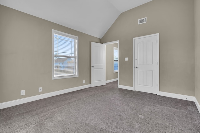 carpeted spare room with vaulted ceiling