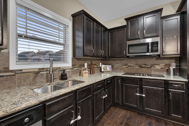 kitchen with decorative backsplash, appliances with stainless steel finishes, dark brown cabinets, dark wood-type flooring, and sink