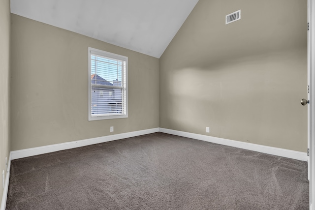 carpeted spare room with vaulted ceiling