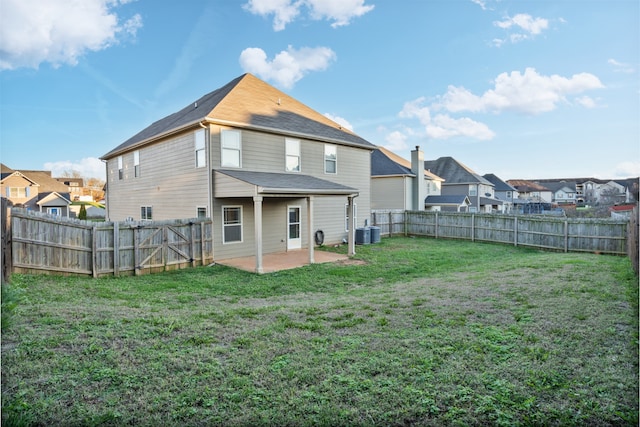 back of house featuring a yard, central AC unit, and a patio area