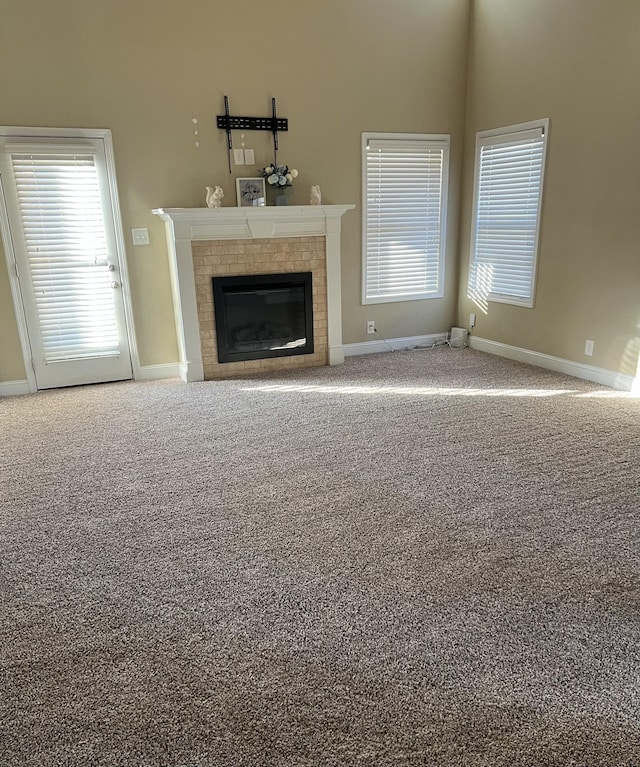 unfurnished living room with carpet flooring and a fireplace