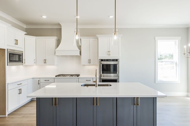 kitchen featuring white cabinets, decorative light fixtures, stainless steel appliances, and custom exhaust hood